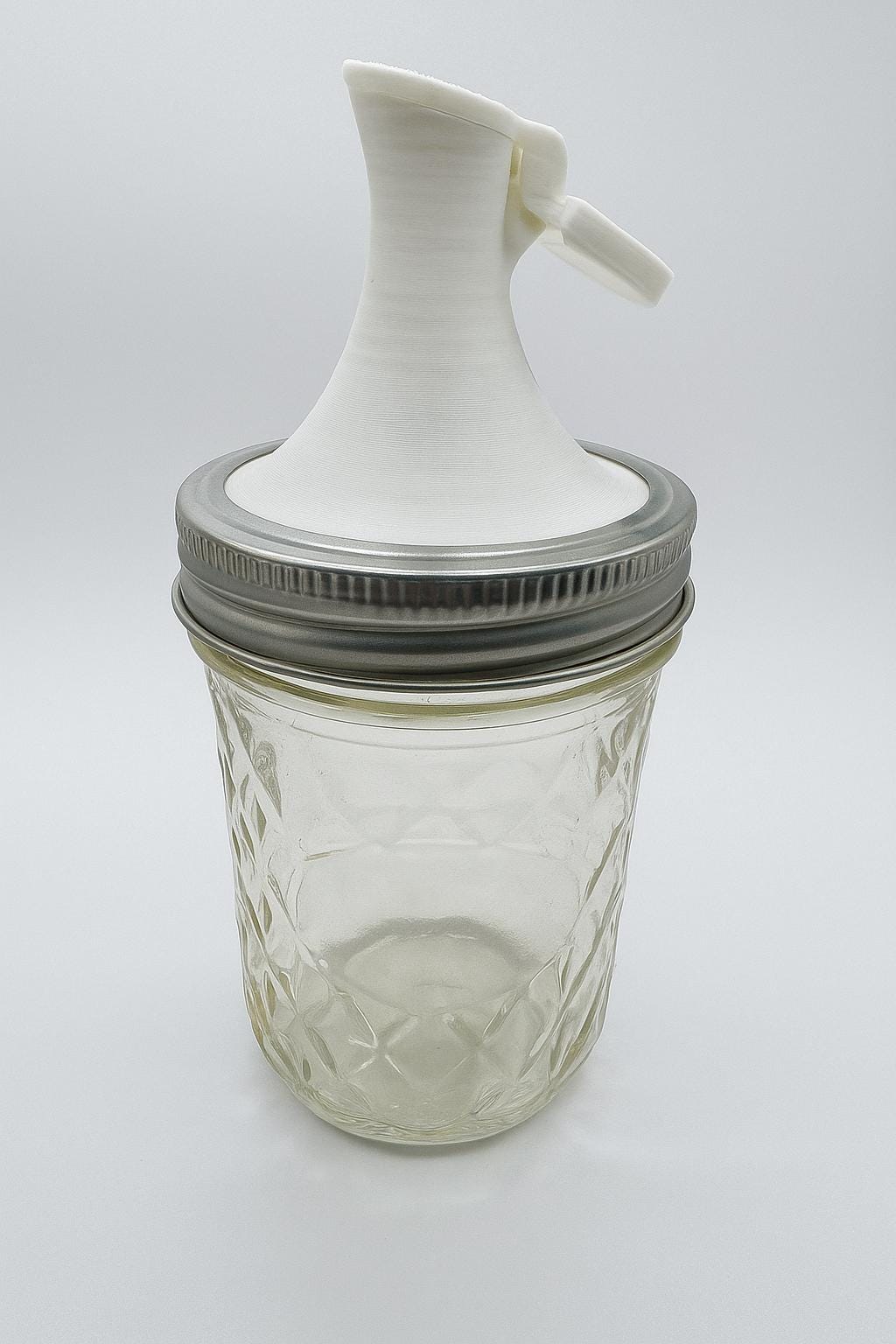 Mason jar pour spout lid for regular-mouth jar dispensing.